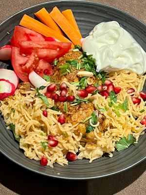 Biryani with  toppings (fried slivered almonds and pomegranate seeds )with a side of plain yogurt and salad 
