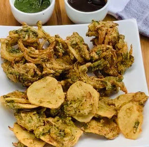Pakodhe (vegetable fritters) vegetables dipped in chickepea flour batter and deep fried.