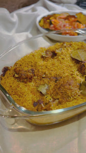 Biryani -close up view showing the fluffy rice and a side dish of squash.